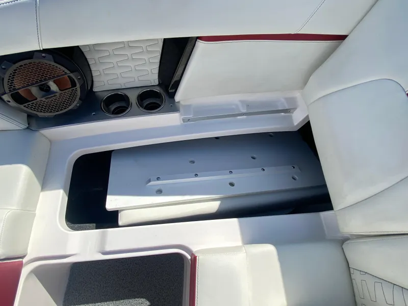 Slide: The Image of 2020 MasterCraft X26 interior with speaker, cup holders, and storage compartment. - 35