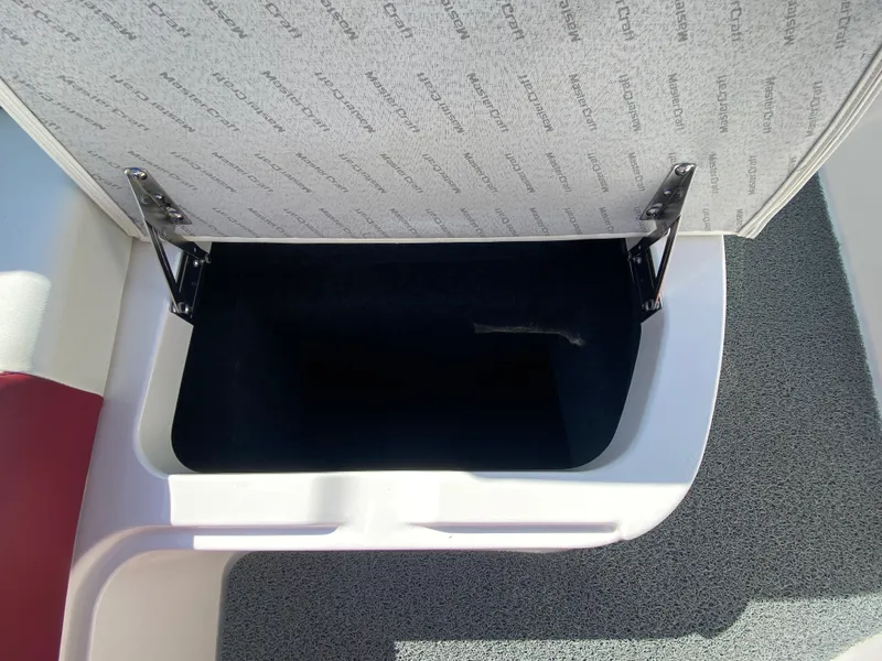 Slide: The Image of Open storage compartment in 2020 MasterCraft X26 boat, featuring durable hinges and spacious interior. - 36