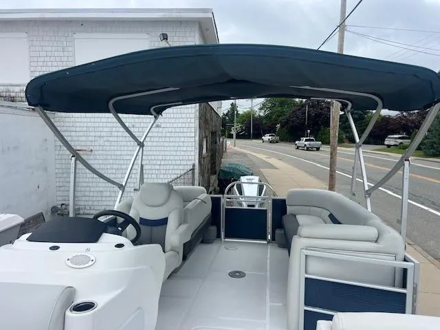 Slide: The Image of 2021 Hurricane FunDeck 236SB OB boat with canopy, parked near a street. - 15