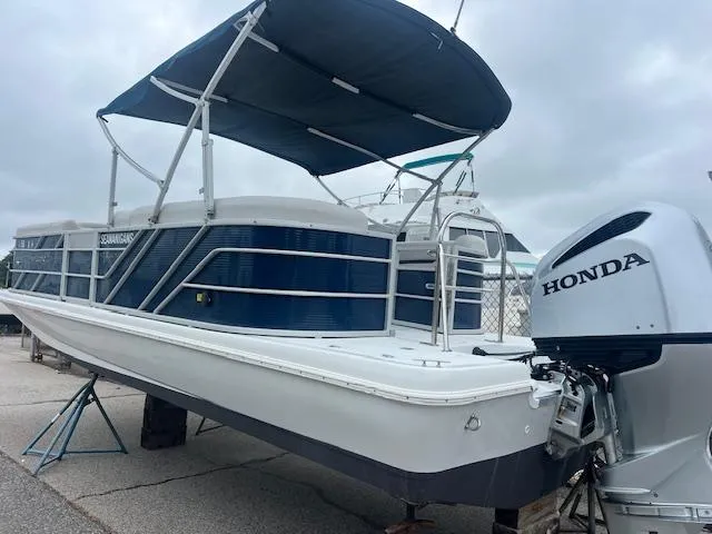 Slide: The Image of 2021 Hurricane FunDeck 236SB OB boat with Honda outboard motor, docked under cloudy skies. - 16
