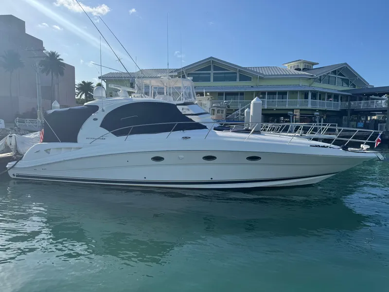The Image of 2005 Sea Ray 420 Sundancer yacht docked at marina under clear blue sky. - 0