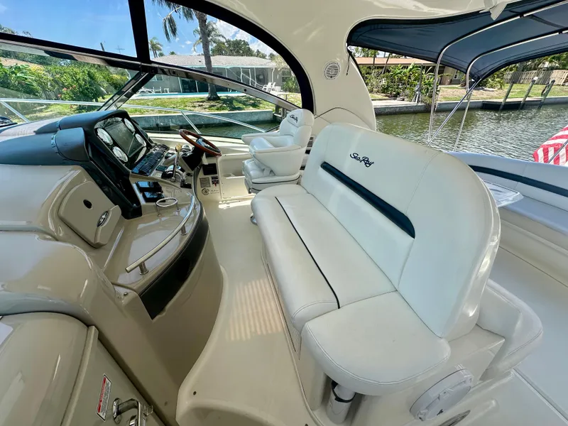 Slide: The Image of 2005 Sea Ray 420 Sundancer cockpit with white seating and modern dashboard controls. - 11