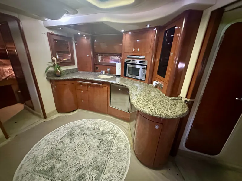 Slide: The Image of Luxurious 2005 Sea Ray 420 Sundancer yacht kitchen with granite countertops and wood cabinetry. - 16