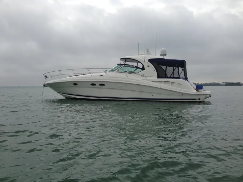 Slide: The Image of 2005 Sea Ray 420 Sundancer yacht on calm waters under cloudy skies. - 2