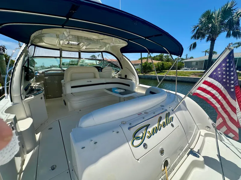 Slide: The Image of 2005 Sea Ray 420 Sundancer yacht with American flag, docked near palm trees. - 5