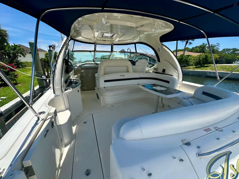 Slide: The Image of 2005 Sea Ray 420 Sundancer yacht interior with seating and table, docked by a canal. - 6