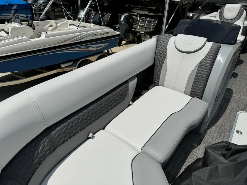 Slide: The Image of 2024 Godfrey Monaco 235 SB boat interior with Garmin navigation system and plush seating. - 14