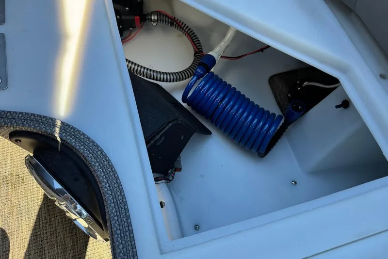 Slide: The Image of Storage compartment of 2024 Godfrey Monaco 235 SB with coiled blue hose. - 30