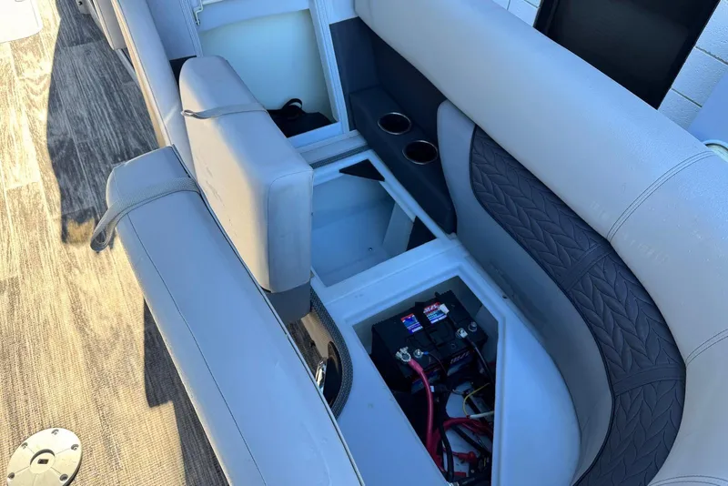 Slide: The Image of 2024 Godfrey Monaco 235 SB boat interior with open storage compartment and battery. - 31