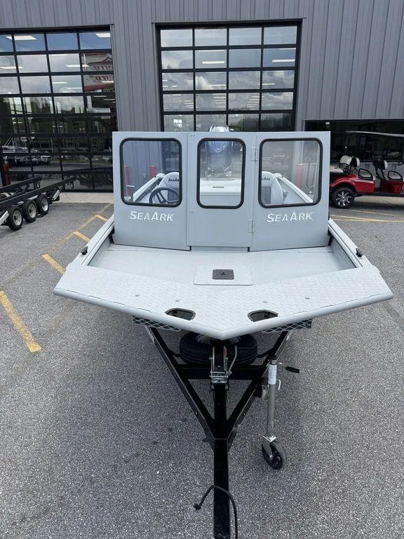 Slide: The Image of 2026 SeaArk 2072 MV Flat Cat boat on trailer, parked outside a building. - 1