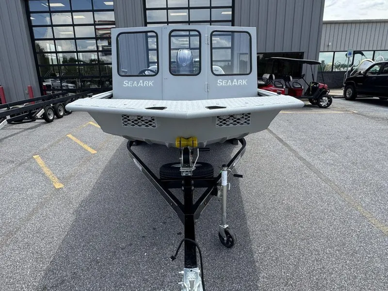 Slide: The Image of 2026 SeaArk 2072 MV Flat Cat boat on trailer, parked outside a building. - 6