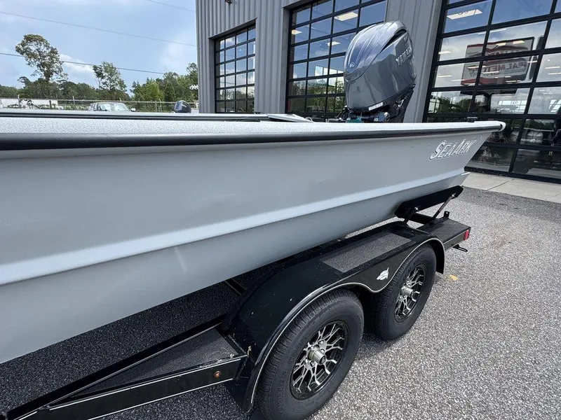 Slide: The Image of 2026 SeaArk 2072 MV Flat Cat boat on trailer, parked outside a building. - 7