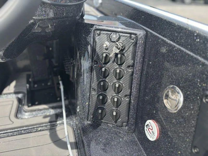 Slide: The Image of Control panel of 2026 Phoenix 921 Elite X II boat with switches and key. - 21