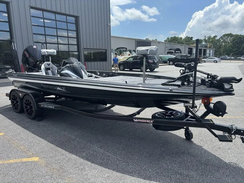 Slide: The Image of 2026 Phoenix 921 Elite X II boat on trailer, parked outside a modern building. - 8