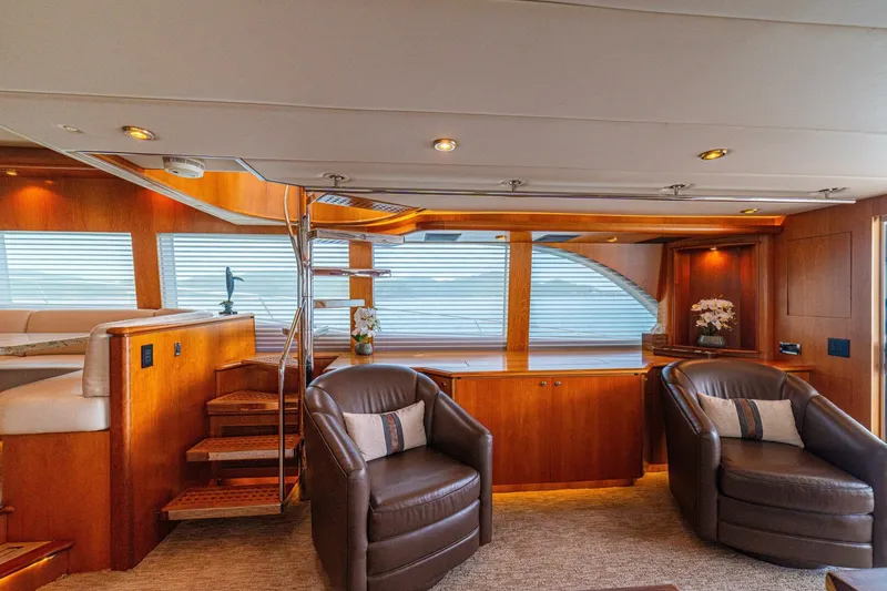 Slide: The Image of Luxurious interior of 2002 Queenship 98 Yachtfish with leather chairs and wooden accents. - 13