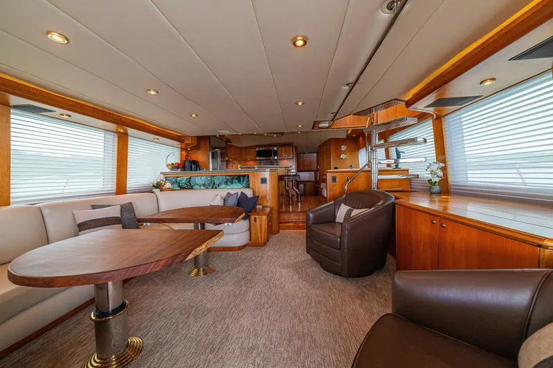 Slide: The Image of Luxurious interior of 2002 Queenship 98 Yachtfish, featuring elegant seating and wooden accents. - 15