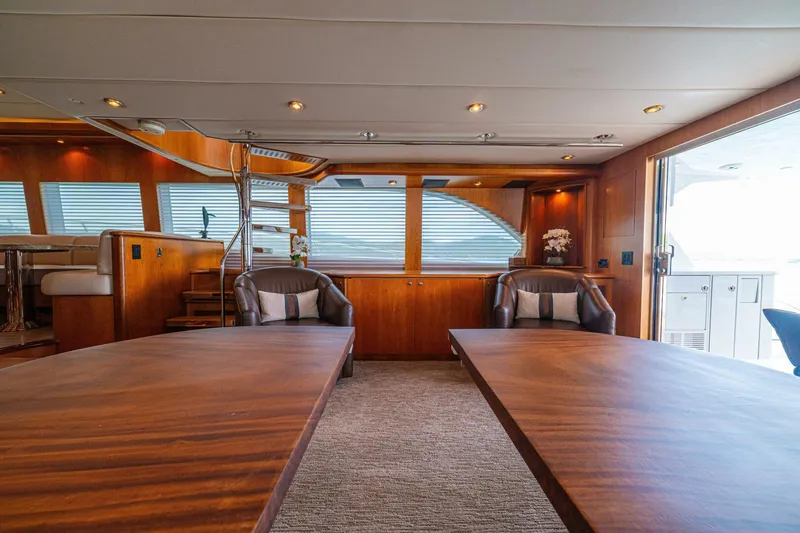 Slide: The Image of Luxurious interior of 2002 Queenship 98 Yachtfish, featuring elegant wood finishes and comfortable seating. - 17