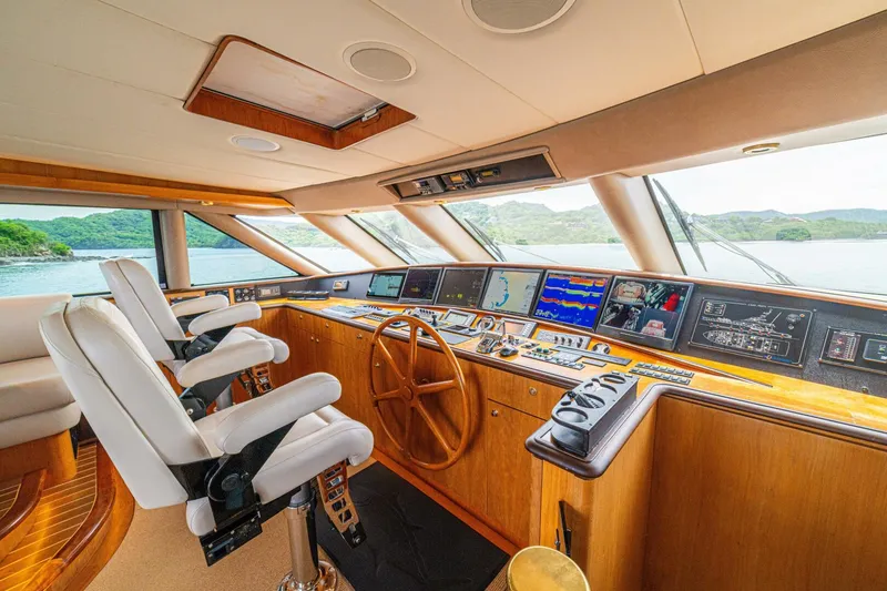 Slide: The Image of Luxurious 2002 Queenship 98 Yachtfish helm with modern navigation systems and plush seating. - 2