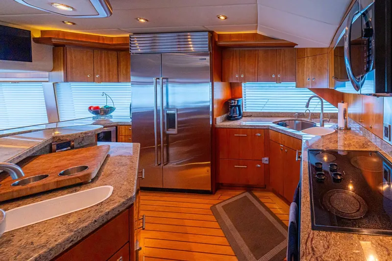 Slide: The Image of Luxurious kitchen interior of 2002 Queenship 98 Yachtfish with modern appliances and wooden cabinetry. - 22