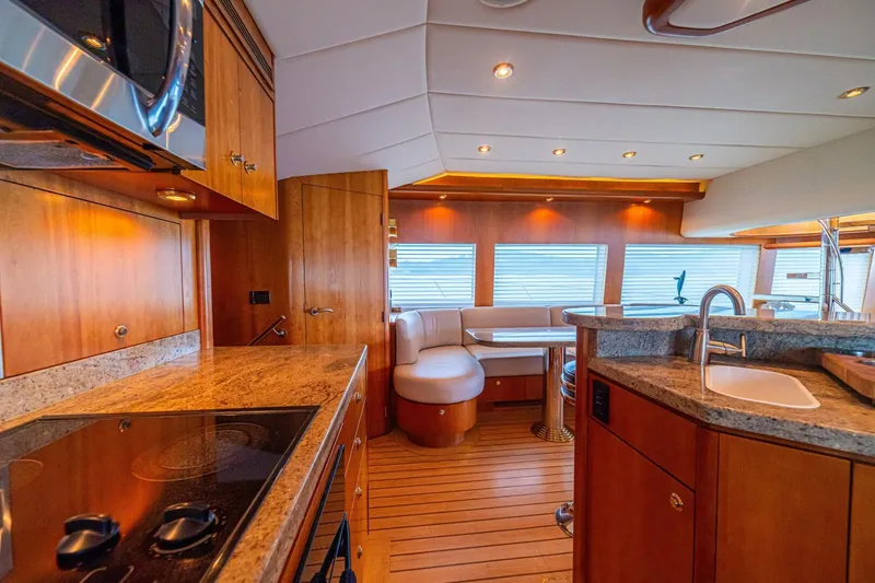 Slide: The Image of Luxurious 2002 Queenship 98 Yachtfish interior with modern kitchen and elegant seating area. - 25