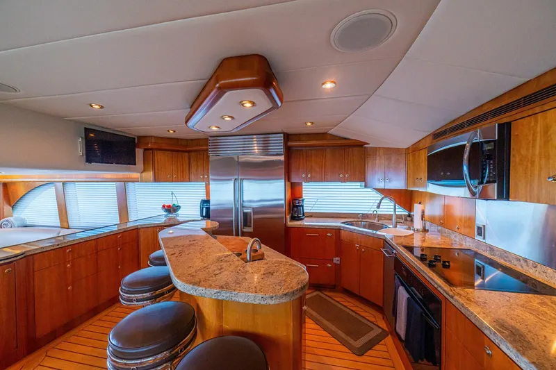 Slide: The Image of Luxurious kitchen interior of 2002 Queenship 98 Yachtfish with modern appliances and wood cabinetry. - 26