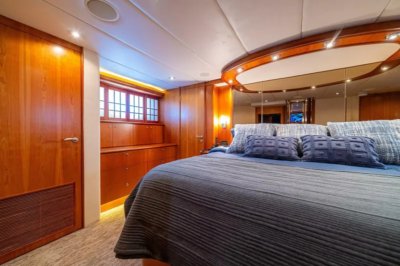 Slide: The Image of Luxurious bedroom interior of 2002 Queenship 98 Yachtfish with elegant wood finishes. - 27