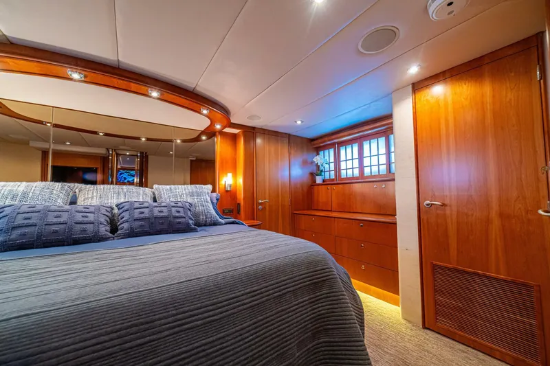 Slide: The Image of Luxurious bedroom interior of 2002 Queenship 98 Yachtfish, featuring elegant wood finishes and cozy bedding. - 28