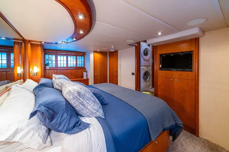 Slide: The Image of Luxurious bedroom in 2002 Queenship 98 Yachtfish with elegant wood finishes and modern amenities. - 32