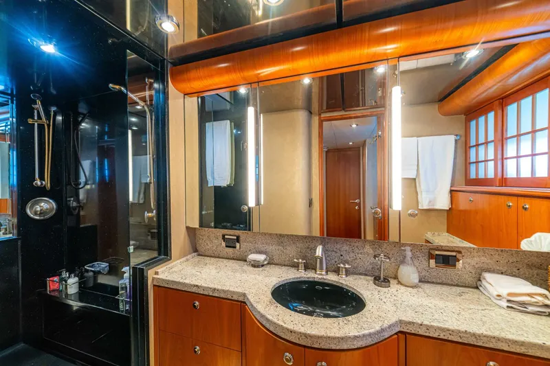 Slide: The Image of Luxurious bathroom on 2002 Queenship 98 Yachtfish, featuring elegant wood and granite finishes. - 35
