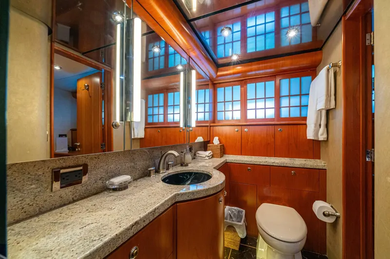 Slide: The Image of Luxurious bathroom on 2002 Queenship 98 Yachtfish, featuring elegant wood cabinetry and modern fixtures. - 37