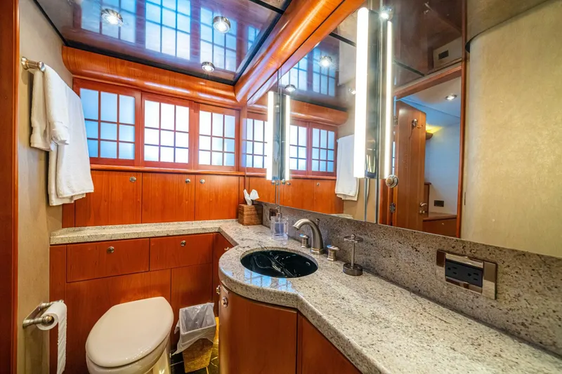 Slide: The Image of Luxurious bathroom in 2002 Queenship 98 Yachtfish, featuring wood cabinetry and granite countertops. - 38
