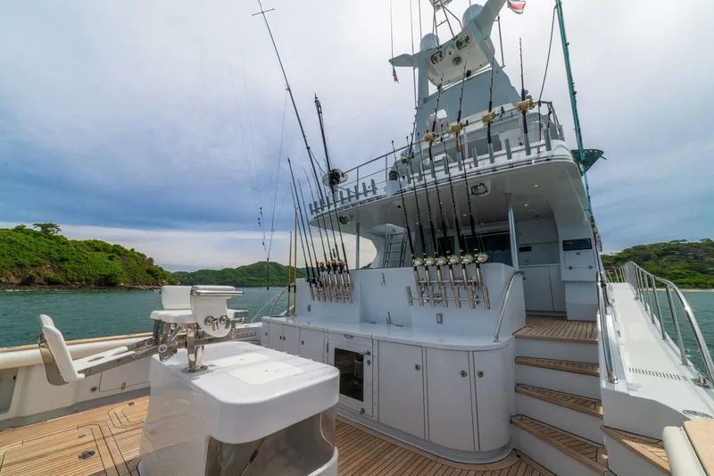 Slide: The Image of Luxurious 2002 Queenship 98 Yachtfish with fishing rods, docked in scenic waters. - 6