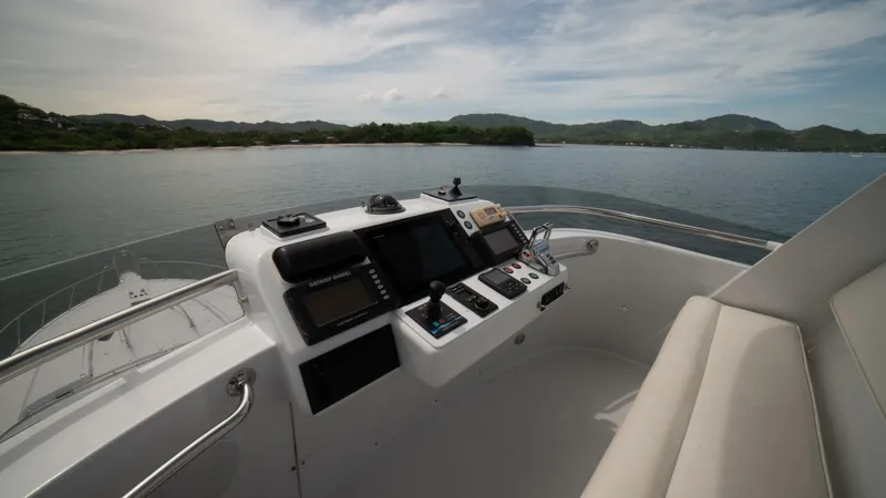 Slide: The Image of Control panel of 2002 Queenship 98 Yachtfish overlooking serene waters and distant hills. - 7