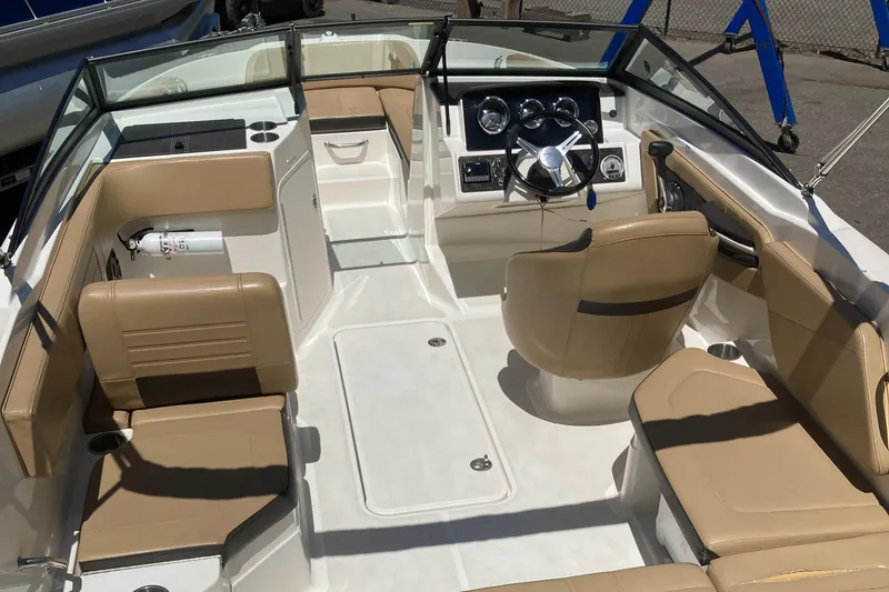Slide: The Image of 2021 Sea Ray SPX 210 Outboard boat interior with beige seating and modern dashboard. - 11