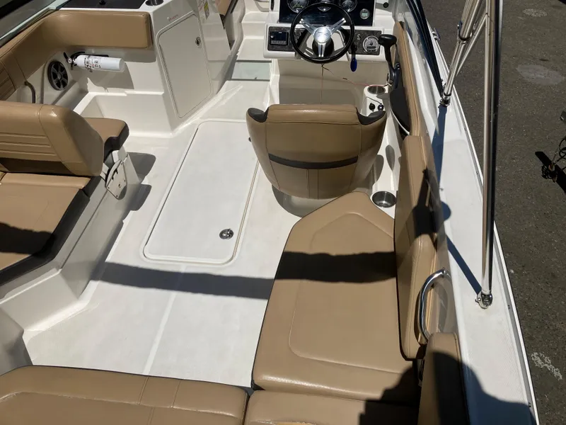 Slide: The Image of 2021 Sea Ray SPX 210 Outboard interior with tan seating and steering console. - 4