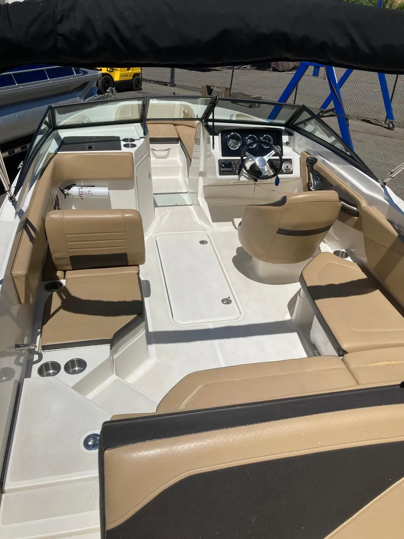 Slide: The Image of 2021 Sea Ray SPX 210 Outboard boat interior with tan seating and modern dashboard. - 5