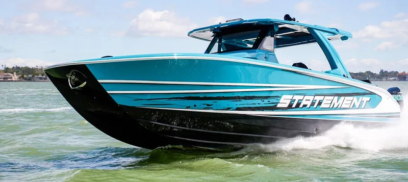 Slide: The Image of 2026 Statement 430 Tigress Center Console Catamaran cruising on water, vibrant blue design. - 2