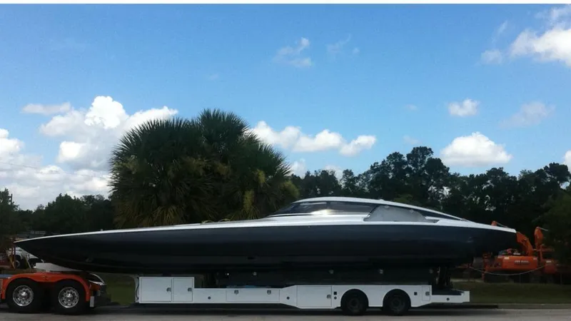 Slide: The Image of 2012 Mystic Powerboats 50 Cat on trailer under blue sky with palm trees. - 6