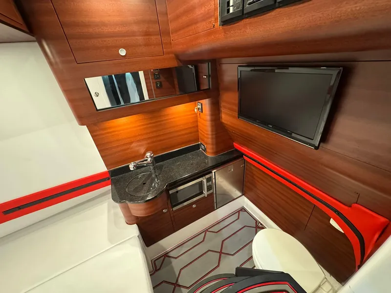 Slide: The Image of Luxurious interior of 2018 Mystic Powerboats M4200 with wood finish, TV, and kitchenette. - 11