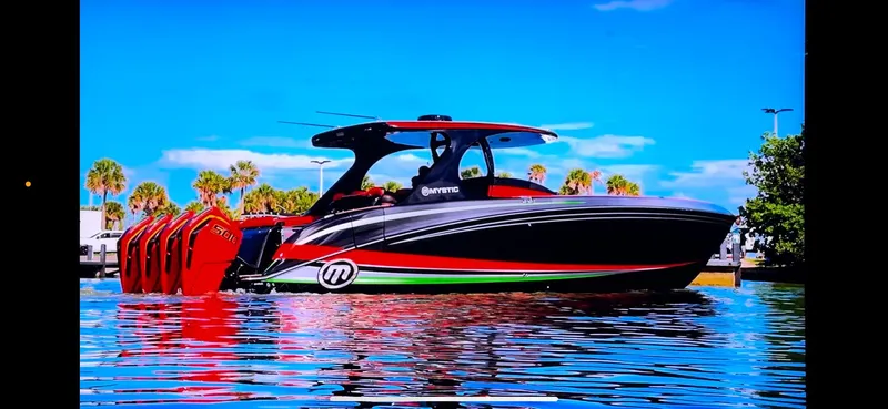 Slide: The Image of 2018 Mystic Powerboats M4200 on water, vibrant design, multiple engines, clear sky background. - 29