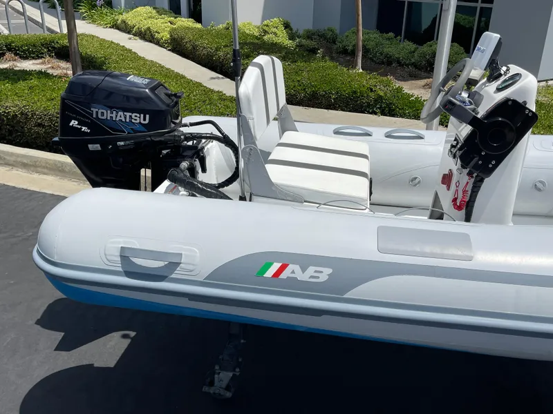 Slide: The Image of 2013 AB Inflatables Lammina 10 AL with Tohatsu outboard motor, parked outdoors. - 13