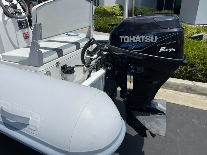 Slide: The Image of 2013 AB Inflatables Lammina 10 AL with Tohatsu outboard motor, parked outdoors. - 4