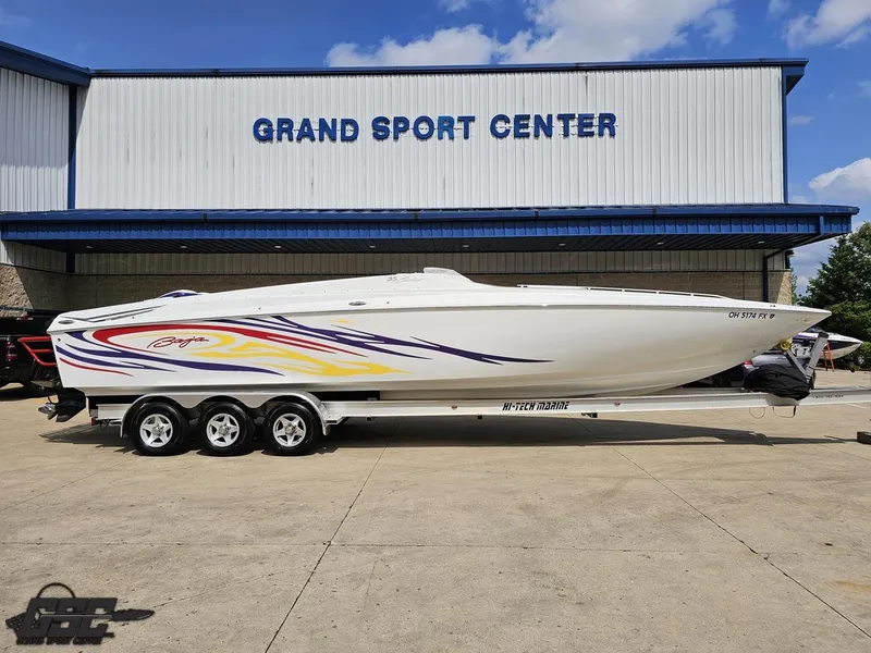 The Image of 2007 Baja 35 Outlaw boat at Grand Sport Center, featuring vibrant graphics and triple-axle trailer. - 1