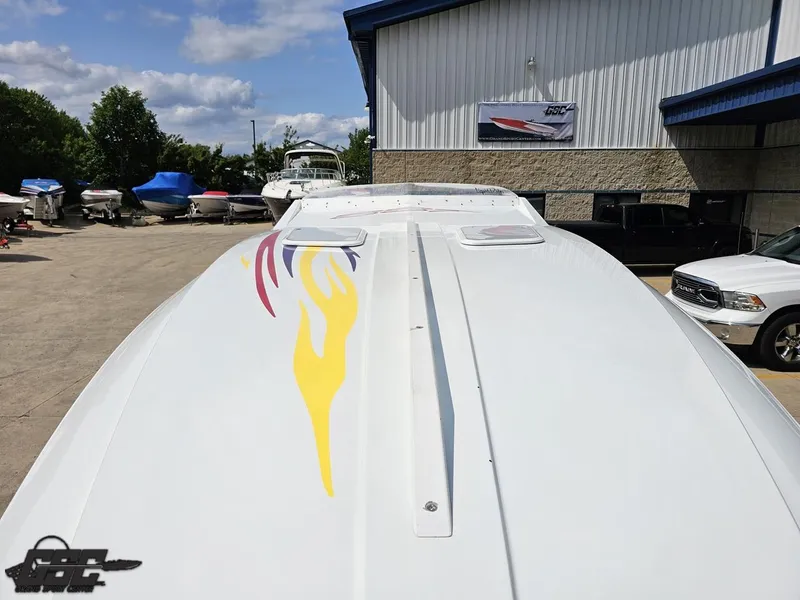 Slide: The Image of 2007 Baja 35 Outlaw boat with colorful flame design, parked outdoors. - 16