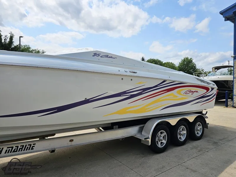 Slide: The Image of 2007 Baja 35 Outlaw boat with colorful graphics on a trailer under a cloudy sky. - 19