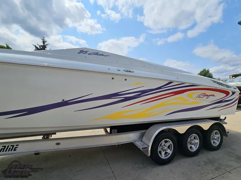 Slide: The Image of 2007 Baja 35 Outlaw boat with colorful graphics on a trailer under a cloudy sky. - 20