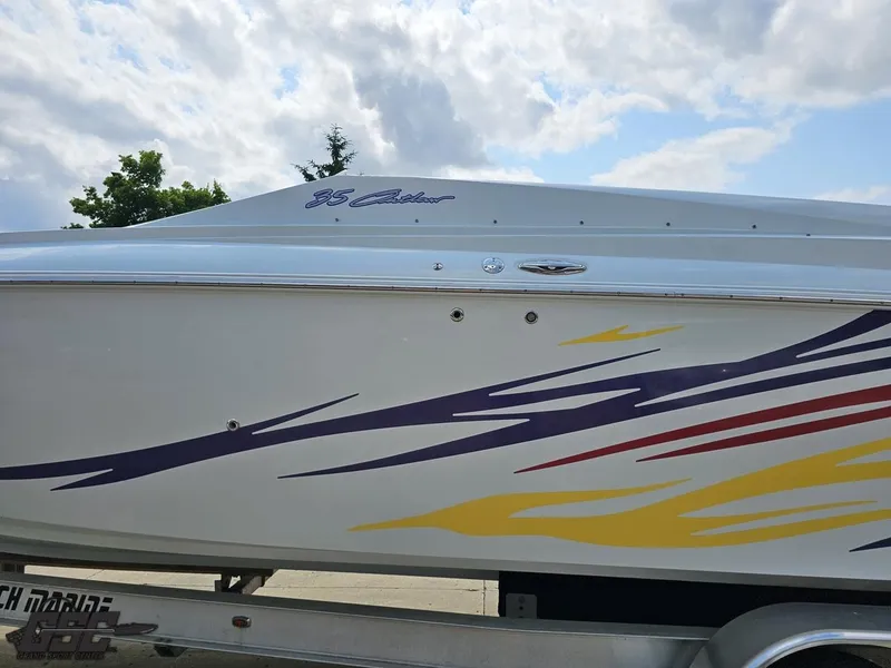 Slide: The Image of 2007 Baja 35 Outlaw boat with colorful graphics on a trailer under a cloudy sky. - 22