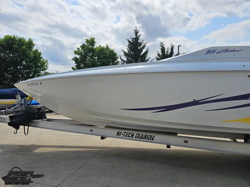 Slide: The Image of 2007 Baja 35 Outlaw boat on trailer, parked outdoors under a cloudy sky. - 23