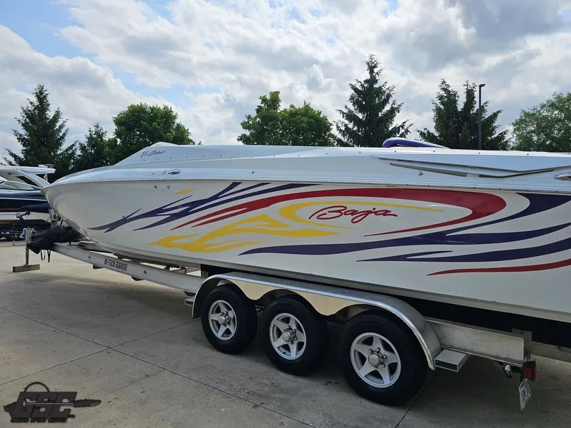 Slide: The Image of 2007 Baja 35 Outlaw boat with colorful graphics on a trailer, parked outdoors. - 27