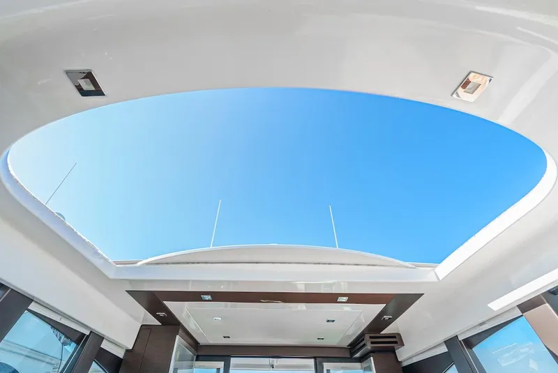Slide: The Image of Open sunroof view on 2016 Tiara Yachts C44 Coupe against clear blue sky. - 25